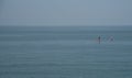 Unrecognized people canoeing in the sea in the morning. People exercising in the ocean Royalty Free Stock Photo