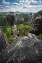 Unrecognized silhouette climber on mountain top enjoying famous Bastei rock formation of national park Saxon Switzerland