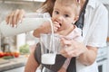 Unrecognized woman with cute baby girl while holding bottle of milk in the room indoors Royalty Free Stock Photo