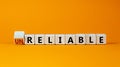 Unreliable or reliable symbol. Turned wooden cubes and changed the word unreliable to reliable. Beautiful orange background, copy Royalty Free Stock Photo