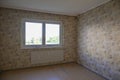 Unrenovated empty room with an old patterned wallpaper on the walls, concept for housing and shortage of affordable living space,