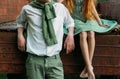 Unrequited first love. a barefooted girl in a green dress sits on the back of a car and hugs a barefoot, next to a standing guy, a Royalty Free Stock Photo