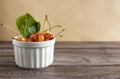 unripe cherry berries in a white bowl on a wooden background Royalty Free Stock Photo