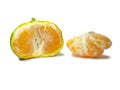 Unripe tangerine. Peeling a tangerine. Green fruit on a white background. Sour ingredient. Citrus isolate. Sliced green mandarin Royalty Free Stock Photo