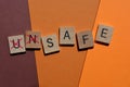 Unsafe, word in wooden alphabet letters