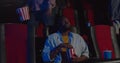 Unsatisfied spactators exept one african guy in movie theatre. People standing and walking during film in cinema while