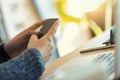 Unseen woman telecommutes, smartphone and laptop in kitchen Royalty Free Stock Photo