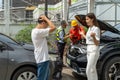 An unset young woman talking angryly to a man who accidentally drove his car and hit her car