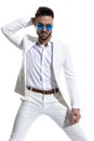 Unshaved fashion man with retro sunglasses holding hand behind head