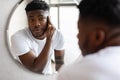 Unshaven Black Guy Touching Face Preparing For Shaving In Bathroom Royalty Free Stock Photo