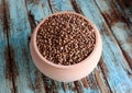 Unshelled food hemp seeds in a wooden pot on an old painted, shabby wooden background. Royalty Free Stock Photo