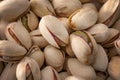Unshelled nuts and healthy vegetarian foods close up on a pile of roasted and salted pistachios in shell texture, background