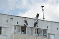 unskilled labor - migrant workers work on high-rise work on the roof of a house in Moscow Royalty Free Stock Photo