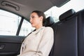 Unsmiling businesswoman sitting in the back seat Royalty Free Stock Photo