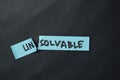 Unsolvable to be Solvable write on sticky notes isolated on office desk