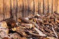 Unsorted wood pile against weathered wood-sided building. Royalty Free Stock Photo