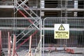 Unstable building keep out dangerous sign on fence at building construction site Royalty Free Stock Photo