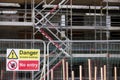 Unstable building keep out dangerous sign on fence at building construction site Royalty Free Stock Photo