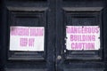 Unstable building keep out dangerous sign on fence at building construction site Royalty Free Stock Photo