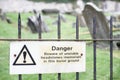 Unstable headstones memorials at burial ground gravestones danger sign