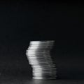 Unstable stack of coins on a black background