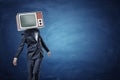 An unsteady businessman standing unevenly with a large retro TV on his head showing gray noise.