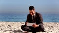 Unstressed businessman using tablet pc on the beach