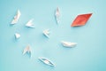 Unsuccessful leadership concept. Red paper boat and a lot of sinking ships Royalty Free Stock Photo