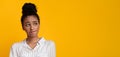 Unsure Afro Girl Looking Aside At Copy Space Over Yellow Background Royalty Free Stock Photo