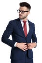 Unsure businessman adjusting his jacket and looking away Royalty Free Stock Photo