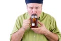 Unsure man tasting cup of herbal tea on white