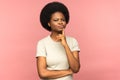 Doubtful black woman touching chin, frowning, pondering, looking at camera doubtfully, studio. Royalty Free Stock Photo