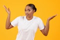Unsure Puzzled Black Woman Shrugging Shoulders Against Yellow Studio Backdrop Royalty Free Stock Photo