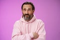 Unsure troubled caucasian bearded adult guy with earring pink hoodie press lips frowning counting mind standing hesitant