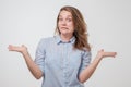 Unsuspecting woman shrugs shoulders of helplessness being unsure Royalty Free Stock Photo