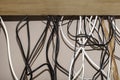 Untidy cables hanging behind a computer desk