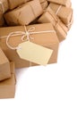 Untidy stack of brown paper packages, border, one with with blank manila label, isolated on white background