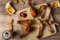 An untidy wooden table with a plate of deep fried or grilled seasoned chicken drumsticks with half eaten, leftover bones, Royalty Free Stock Photo