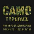 Camo alphabet typeface. Stencil type letters and numbers on a dark background. Royalty Free Stock Photo