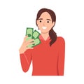 Young rich woman holding dollar bills in hands excited with win or promotion