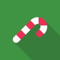 Candy cane sweet stick icon. Christmas or New Year festive flat icon. White cane with red stripes isolated on green background.