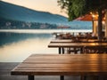 Empty wooden table top with blurred lakeside cafe on gorgeous lake, product display