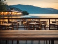 Empty wooden table top with blurred lakeside cafe on gorgeous lake, product display Royalty Free Stock Photo