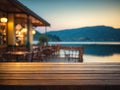 Empty wooden table top with blurred lakeside cafe on gorgeous lake, product display