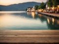 Empty wooden table top with blurred lakeside cafe on gorgeous lake, product display