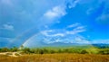 Rainbow over natural landscape, green nature with blue sky view Royalty Free Stock Photo