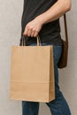 Blank Kraft Paper Bag with Handles Held by Person	- AI generaetd Royalty Free Stock Photo