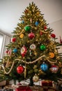 A decorated Christmas tree adorned with colorful ornaments, including red, green, and blue baubles,AUI Royalty Free Stock Photo