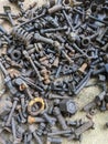 A large collection of rusty metal bolts, nuts, and screws scattered on a rough, concrete surface Royalty Free Stock Photo