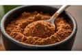 Rich brown cocoa powder in black bowl with metal spoon Royalty Free Stock Photo
